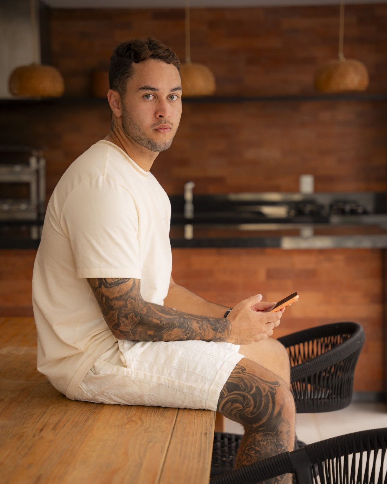 Keven Borges na cozinha de casa, com o celular na mão